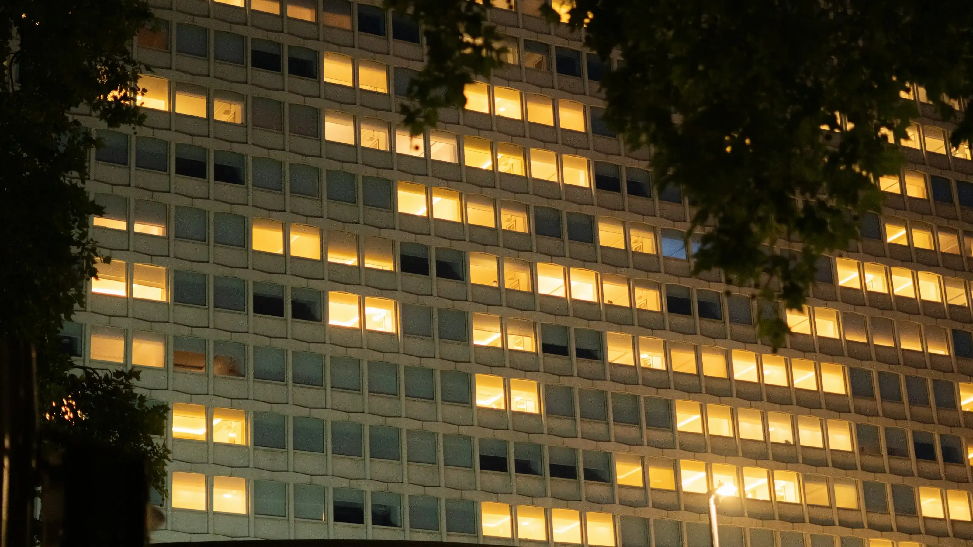 An office building at night with a few windows still lit