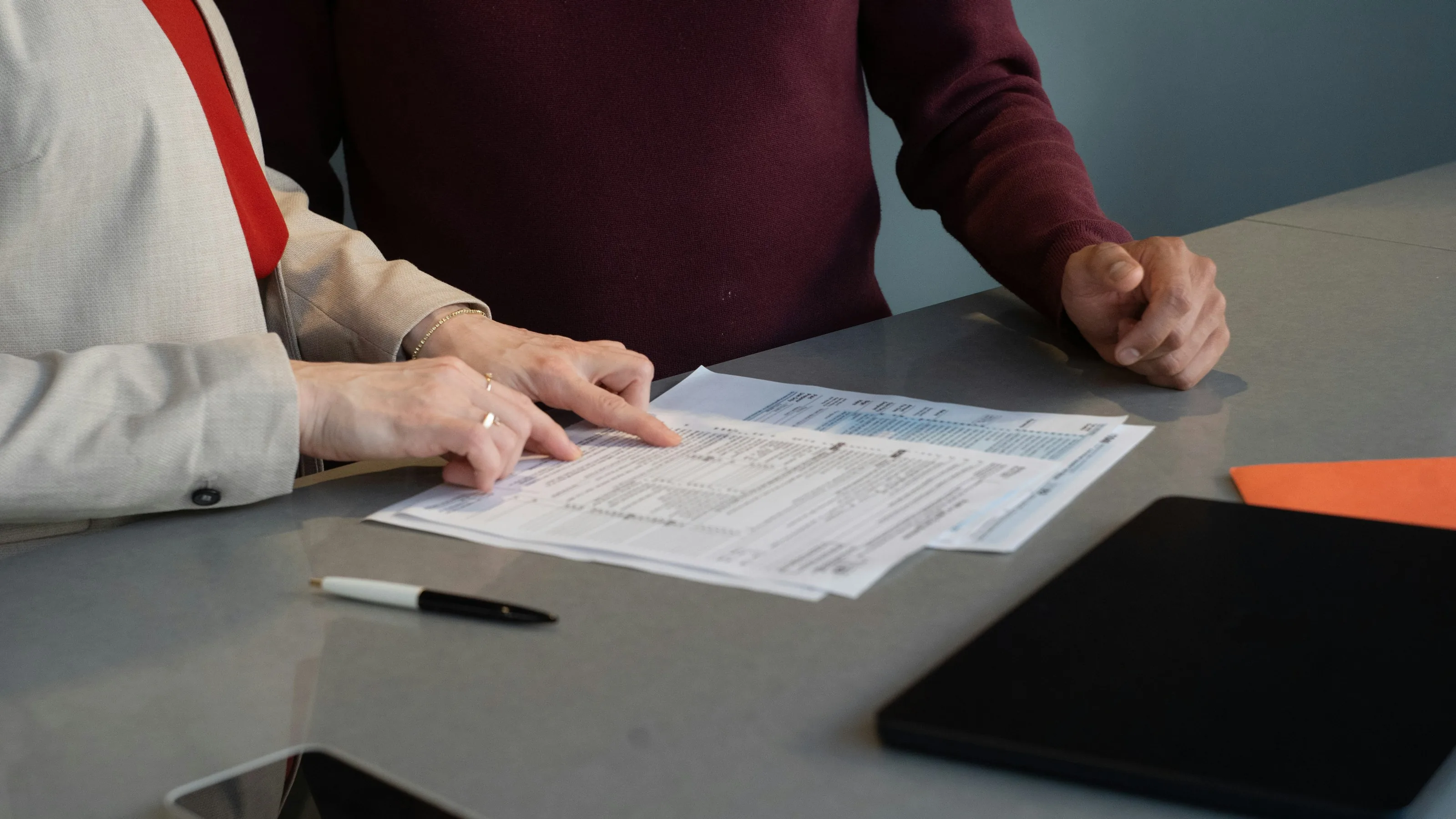 Two people reviewing paperwork together at a table