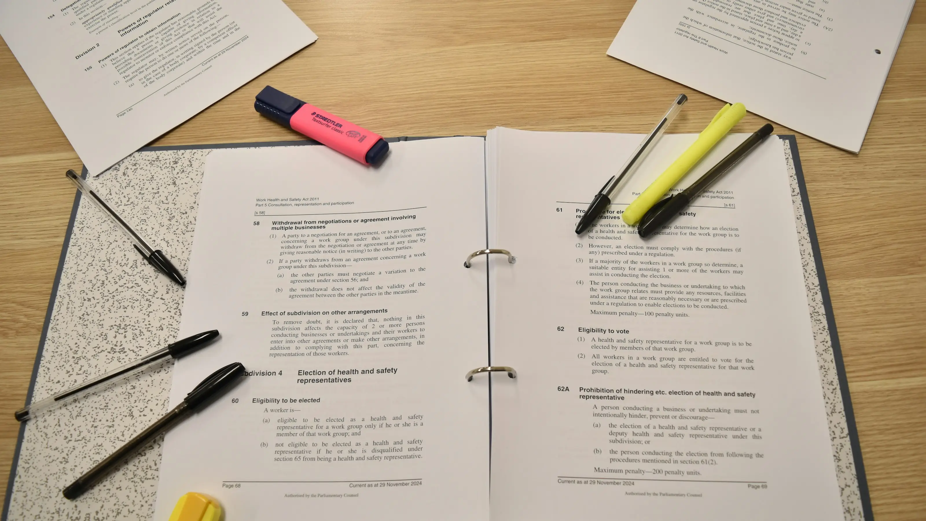 Printed pages, pens and highlighters laid out across a desk