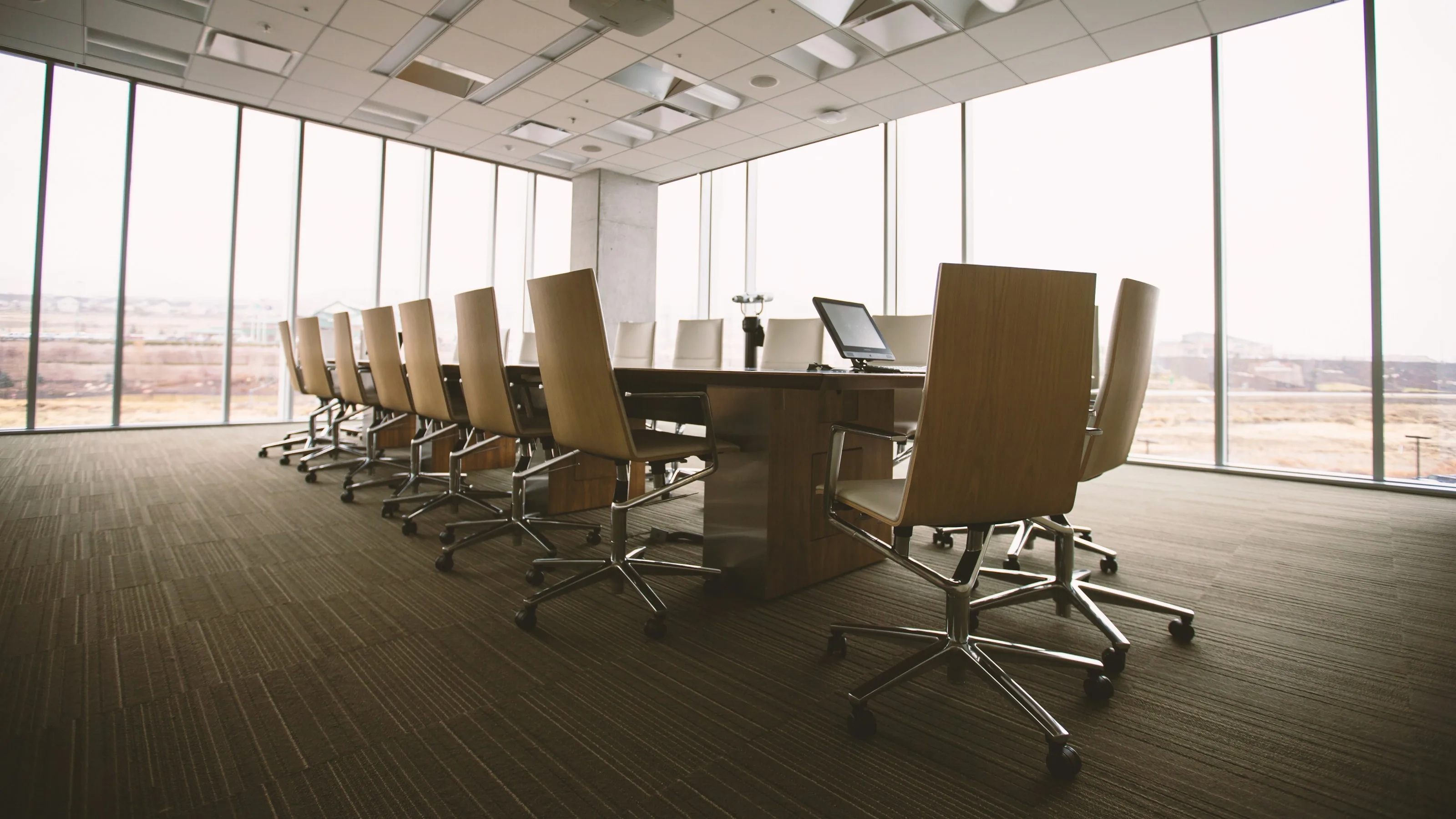 An empty boardroom with a long meeting table