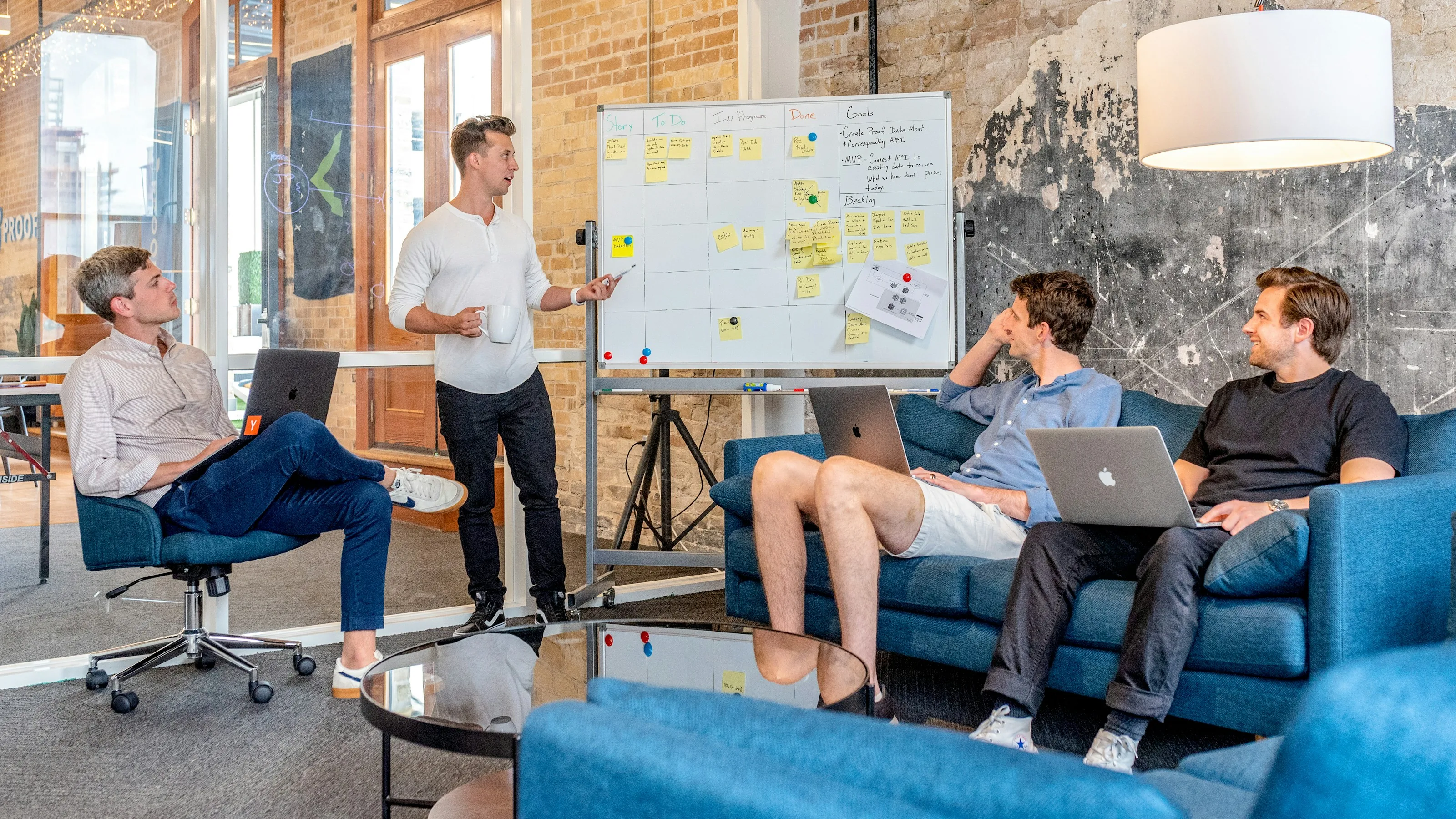 People around a meeting table with notes and a laptop